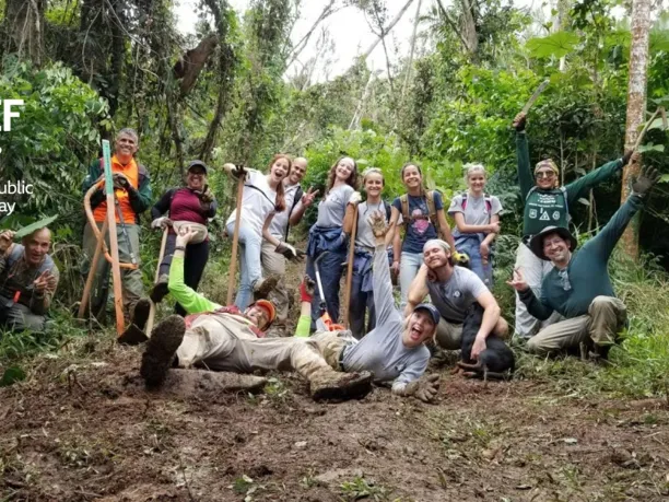 group of National Public Lands Day volunteers smiling with excited expressions while working in the jungle