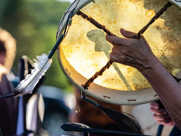 Person holding tambourine with feather