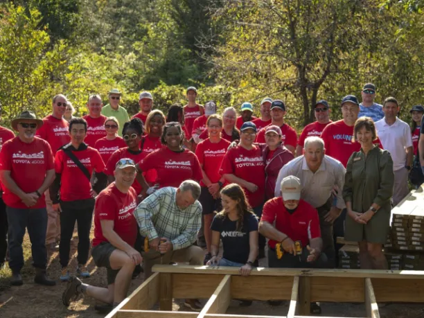 Toyota employees and NEEF in front of a wood boardwalk that is being built