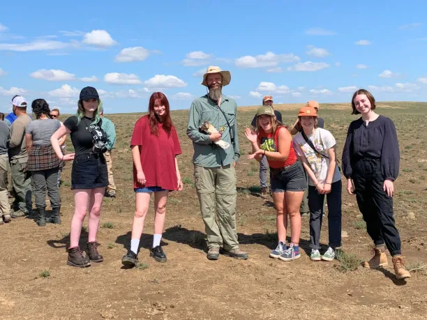 BLM instructor holds a raptor with a group of students during a Greening STEM 