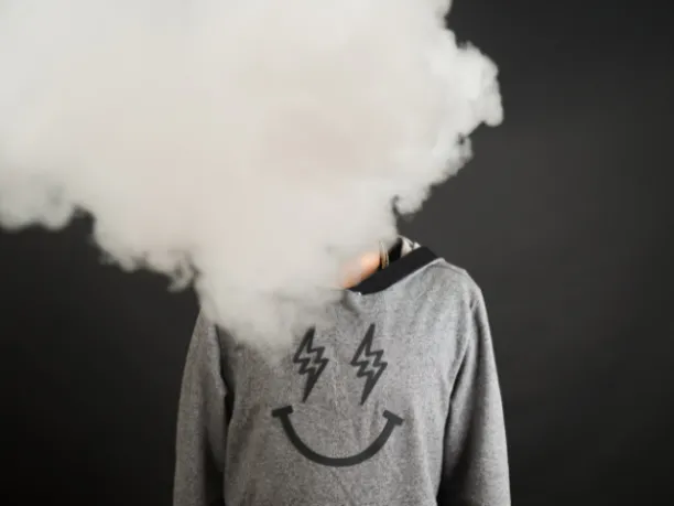 A person's face is covered by a cloud of smoke