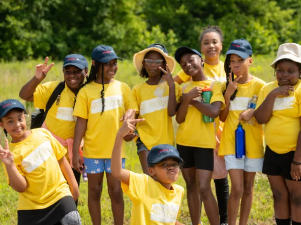 Young girls in a group smiling outdoors