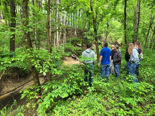 students from University of Southern Indiana survey a trail on campus