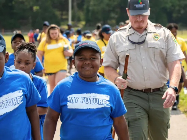a young student smiles while walking with other students during an environmental education program