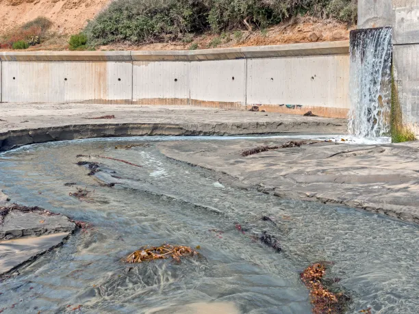 Hillside storm drain runoff on sandy beach