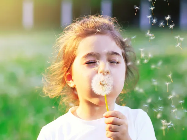 Girl blowing dandelion