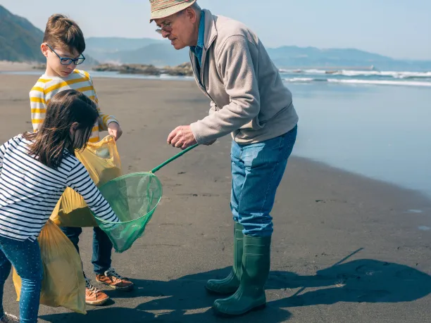 Kids and their grandfather at a beach clean-up