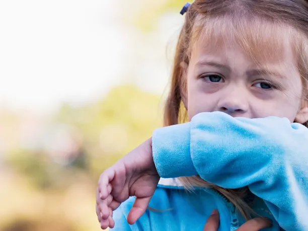 Girl coughing into her elbow