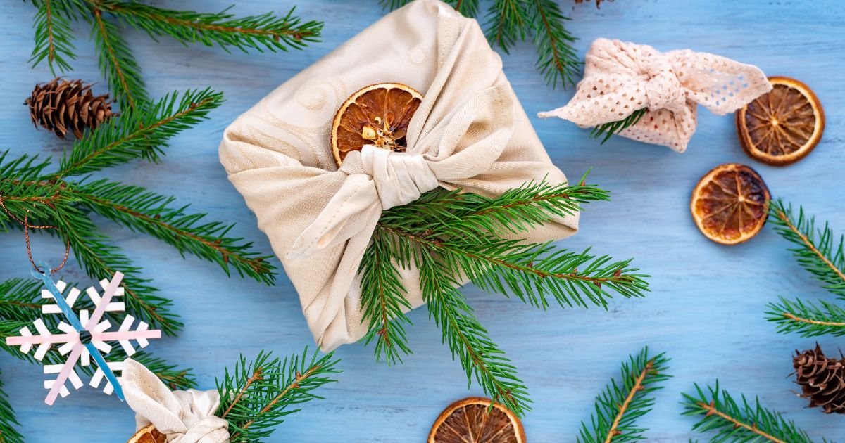 Zero waste gifting wrapping using cloth wrap, dried oranges and pine tree sprigs