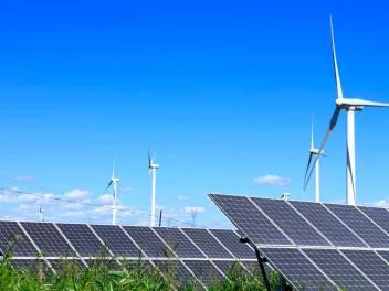 photo of solar panels in field with wind turbines sustainability