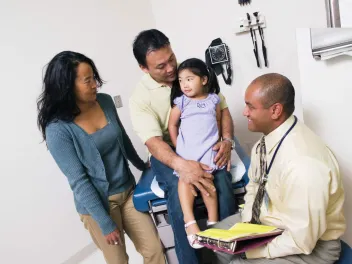 Doctor with parents and young child