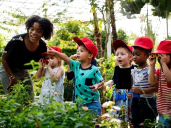 Teacher with young students in an outdoor setting