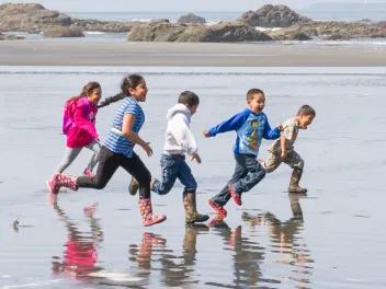 Happy kids running along the beach 