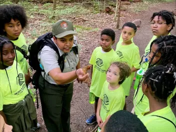 a national park ranger explains an insect to a group of students during a Greening STEM project