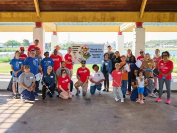 a group of NPLD volunteers stand for a group photo in front of sign National Public Lands Day, Thank You Volunteer, Fish Trap Lake