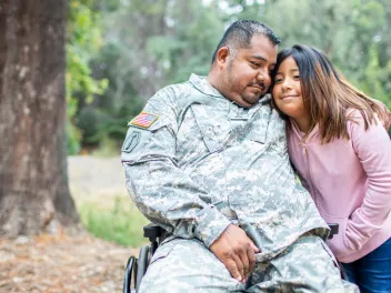 a veteran embraces his daughter in the forest