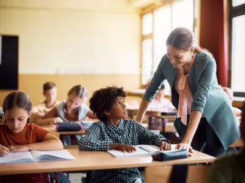 a teacher smiles at a student who looks concerned