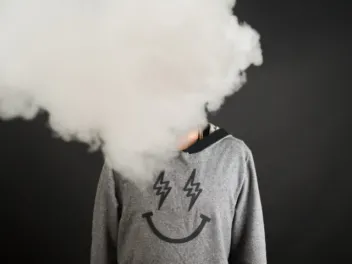 A person's face is covered by a cloud of smoke