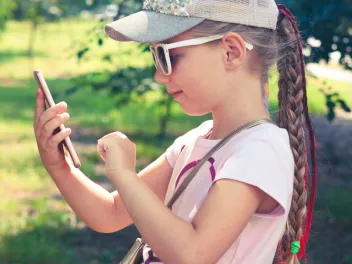 a young girl uses a cellphone outside