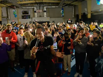 AY Young performing in front of group of students in gymnasium