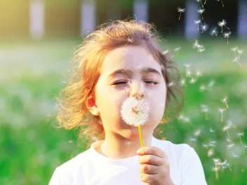 Girl blowing dandelion