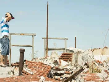 Man surveying destruction from a natural disaster