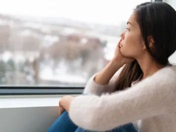 Seasonally depressed woman staring out the window