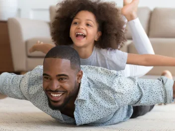 Father and daughter playing indoors