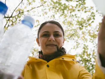 Woman putting plastic recycling into bin