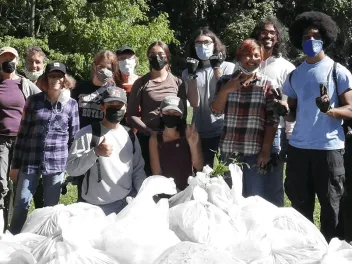 photo of group standing in front of pile of trash bags after a clean-up.