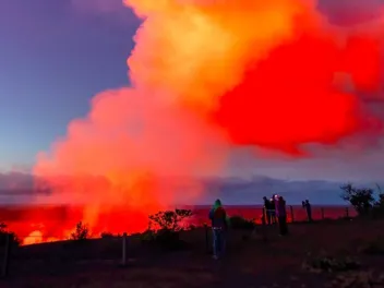 people taking pictures of a  smoldering volcano